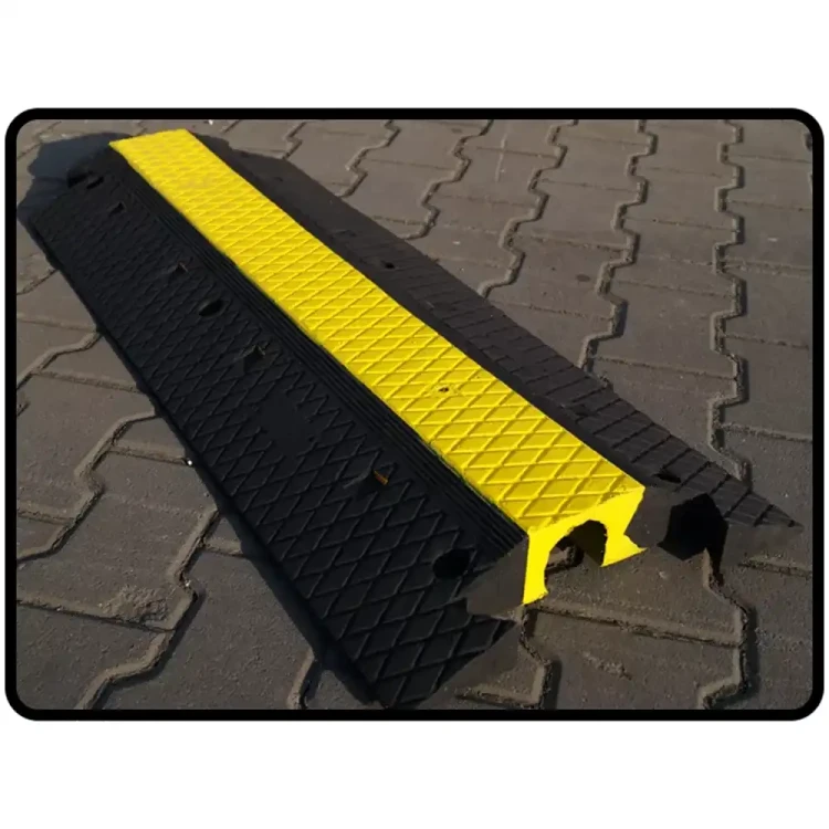 Gumowy najazd kablowy w kolorze czarnym z żółtym, odblaskowym pasem. Chroń kable i przewody na budowie, imprezach plenerowych i parkingach. Najazdy na kable zwiększają bezpieczeństwo i chronią sprzęt
