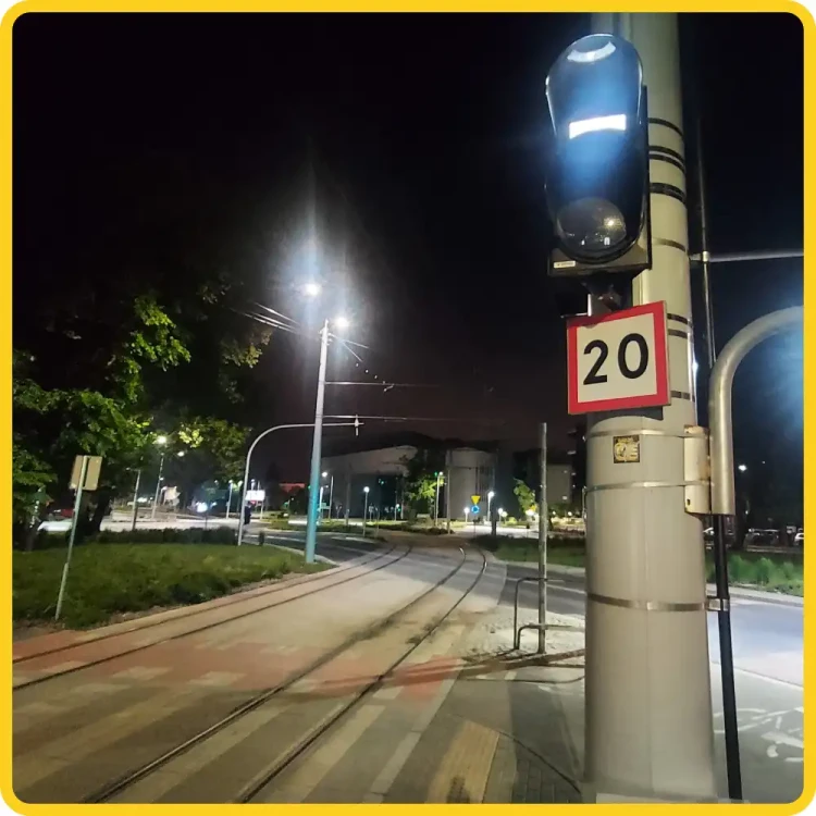 Znak BT-1 - ograniczenie prędkości - folia I generacji 20 km/h, tabliczka na słupie trakcyjnym nocą